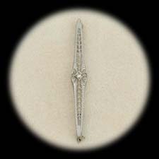 A pretty 14 kt. white gold filagree diamond bar pin ca 1915.  The diamond is .05 ct and the pin measures 57mm x 7mm.