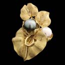 18kt yellow gold floral design with diamond pave accents and one each a black and a white south sea pearl