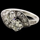 A very pretty 14kt (stamped and tested) 1950's diamond ring. The condition is excellent and there has never been repairs to this ring. This beautiful ring contains 14 single cut and full European cut diamonds set in the swirls flanking the two center diamonds. The ring is set in the middle with two larger diamonds, one an old European cut the other a brilliant cut. The old European cut diamond weighs approximately 0.42 carats and the brilliant cut weighs approximately 0.50 carats. The diamonds are clean SI + and J-K color in the brilliant cut and H-I in the old European cut. Estimated total weight 1.24ct. Overall you'll like it! Size 6.