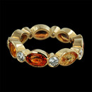 This 18kt yellow gold ''Marbella'' stackable ring by Gumuchian contains bright orange and yellow sapphires with diamond in between.  The sapphires have a total weight of 4.35ct. with .69ct. total weight in diamonds.  The ring measures 5m in width.