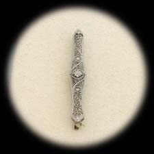 A 14 kt. white gold filagree bar pin ca 1920s.  The piece measures 50mm x 7mm.