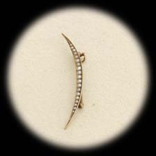 A yellow gold crescent seed pearl pin ca 1890's.  The piece measures 45mm in length and 3mm in width.