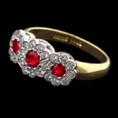 This Charles Green Edwardian 18kt two-tone gold floral cluster ring is set with three  rubies at .30ct total weight and .24ct total weight of diamonds.