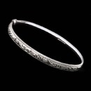 A beautiful hand-made 18kt white gold engraved bangle bracelet from the design studios of master English jeweler Charles Green. The bracelet is hinged and measures 6mm in width. This piece is solid and the best made.