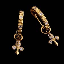 These lovely and whimsical 20kt. gold and diamond hoop earrings are each embellished with a delicate floral charm.
