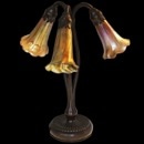 This is a signed Tiffany Studios New York #319 with 3 lights ''Lily'' lamp in mint condition. Two of the shades are signed LCT ( Louis Comfort Tiffany) these shade are without imperfections. The third we believe is a replacement shade and unsigned or we would call the piece near perfect (95%) plus.

The piece stands 13 inches in height with a 4 inch base. The patina is bronzed. The cord is in excellent condition but could not tell you if this is the original. What we do know is this has not been reconditioned for we know the family from whom owned it. Reference Alastair Duncan, Woodbridge: Suffolk: Antique Collectors Club 1988 Pg 59