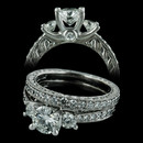 Stunning Scott Kay vintage 3 stone engagement ring made in 14kt white gold. There is intricate detailed engraving on the sides of the band and .39ctw of sparkling diamonds.  The matching wedding ring is $2160.00. Please call for center stone pricing.  