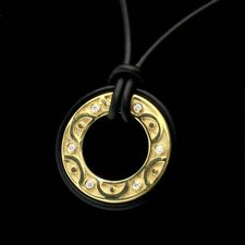 Chris Correia's 18kt round retro pendant with bezel set diamonds black rubber accents and suspended by a black rubber cord.